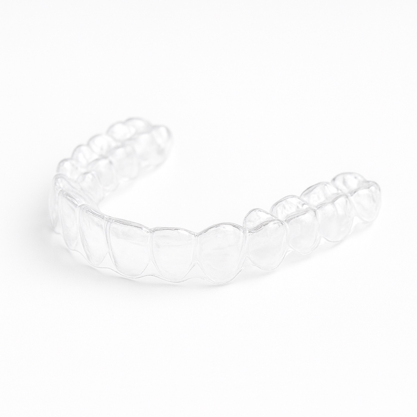 Patient holding Invisalign clear aligner tray and smiling
